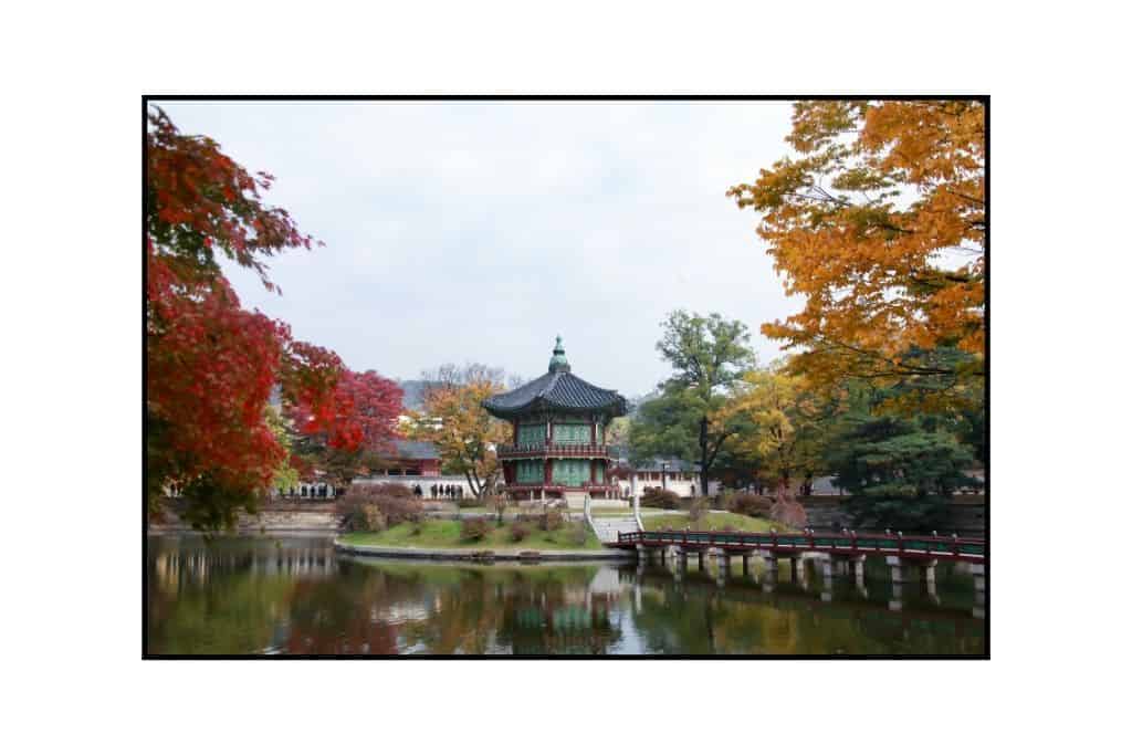 A Gyeonghoeru pavillion and pond at Gyeongbukgung palace in Seoul with autumn foliage