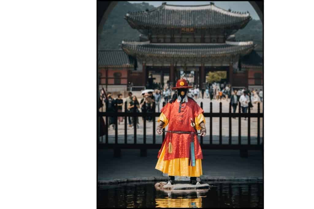 A guard standing in front of the gate at Doksugung Palace 
