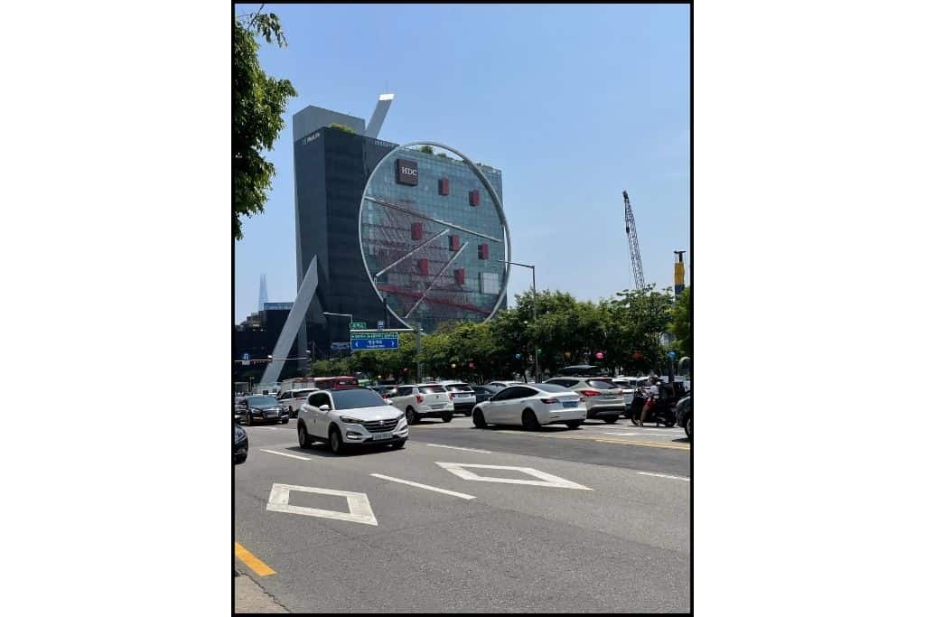 An interesting building in Gangnam, the street and some cars