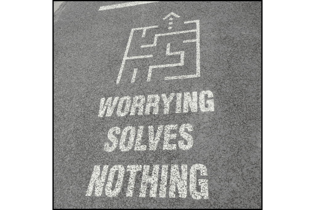 Worrying solves nothing spray-painted on the street at Understand ave
