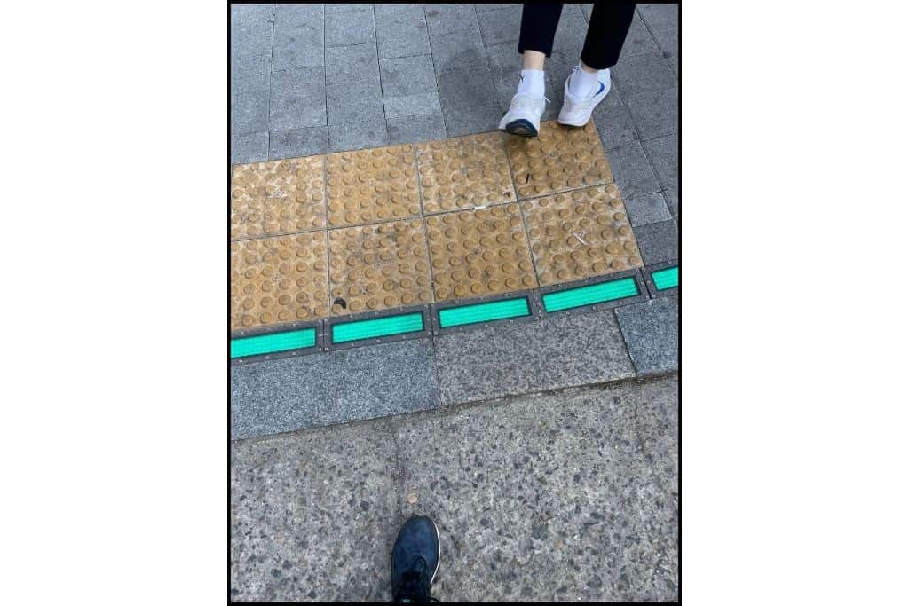 The crosswalk has a green light display on the ground for pedestrians in Seoul