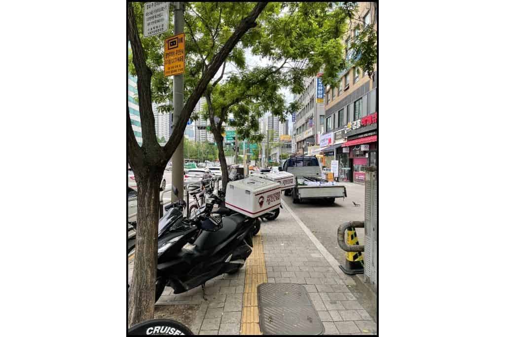 A delivery scooter parked on the sidewalk in Seoul, highlighting the importance of being cautious of scooters and delivery persons ridinf on sidewalks, common mistakes made in South Korea