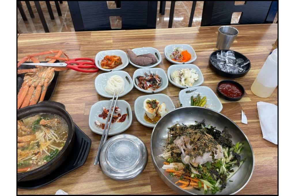 Side dishes known as banchan and a bowl of Korean food at a dine in restaurant.
