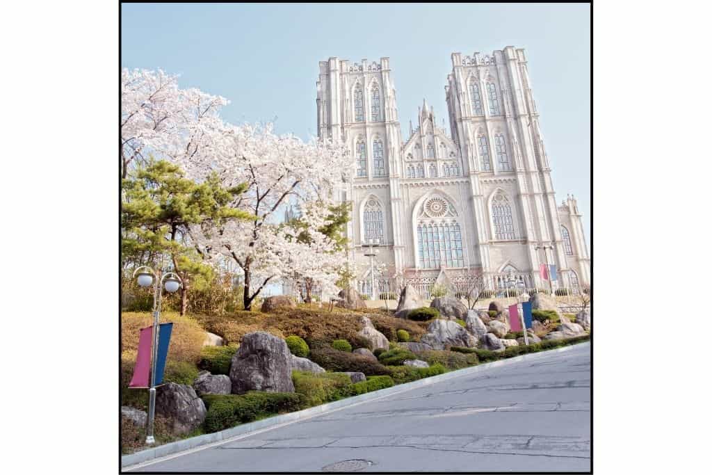 Kyung Hee University gothic style building with pale pink cherry blossoms in Seoul 