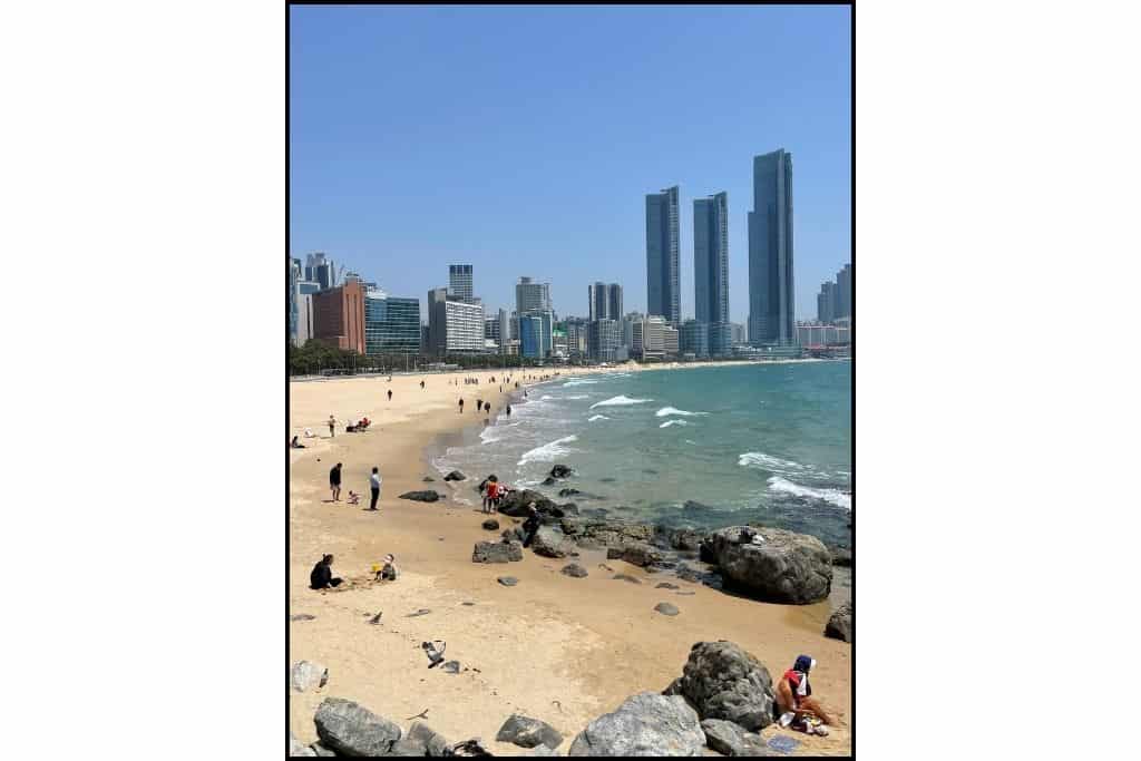 A view of Haeundae beach capturing the sand, sea and iconic buildings