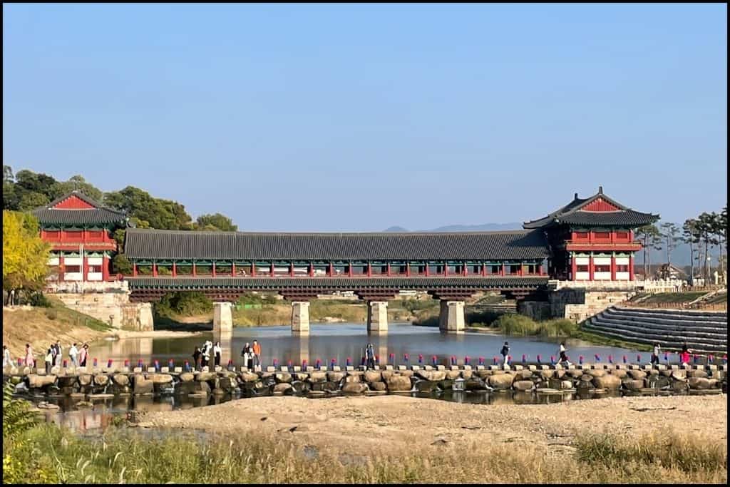 Woljeonggyo Bridge in Gyeongju, South Korea, featuring traditional Korean architecture with a vibrant red and green color scheme, spanning over Hyeongsan River