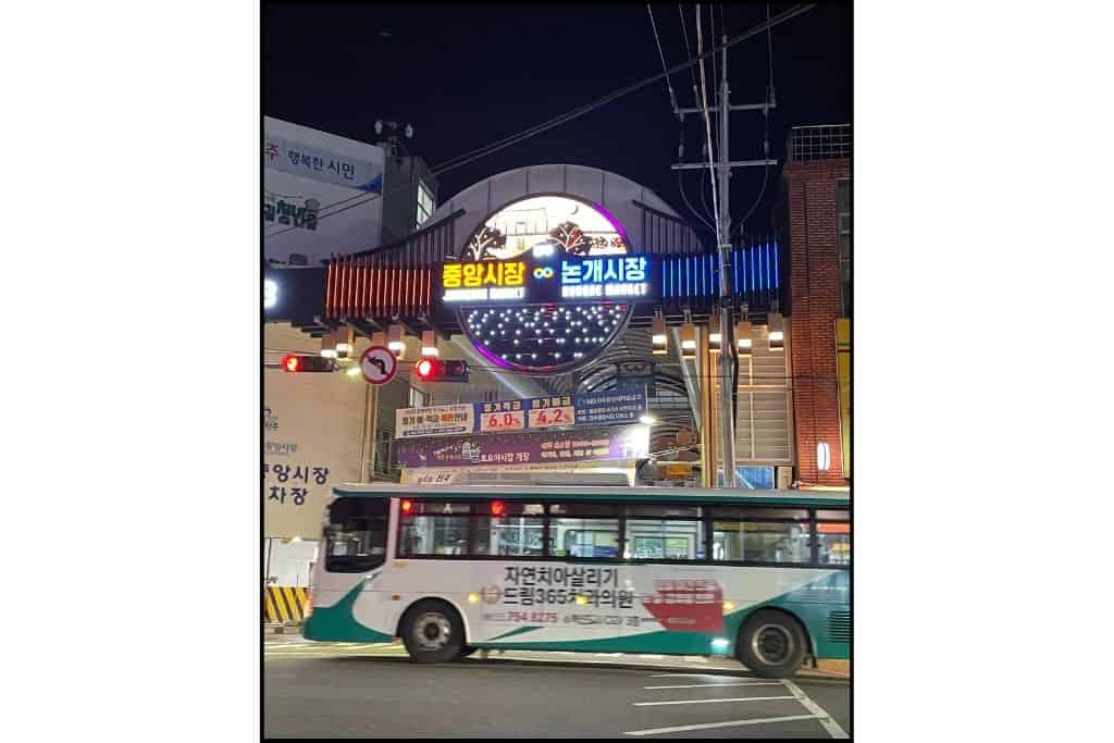 A city bus in front of the entrance to the two traditional markets next to each other in Jinju