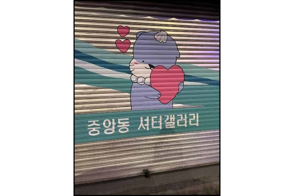 Hamo, the sea otter mascot, hugging a heart