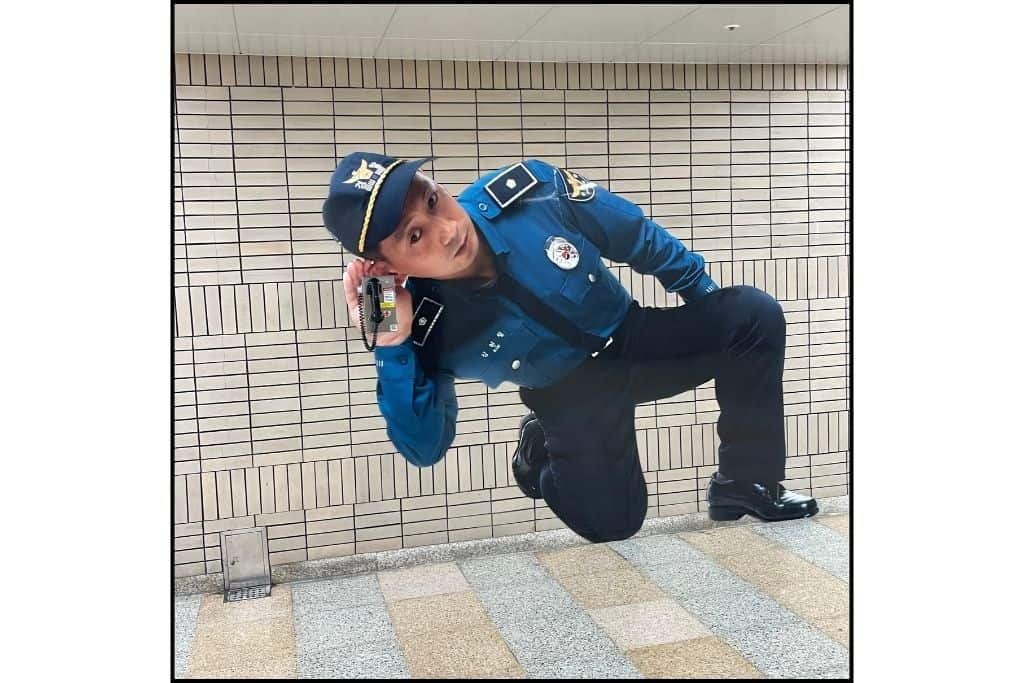 A large photo of a policeman with an emergency phone at his ear in the subway of South Korea