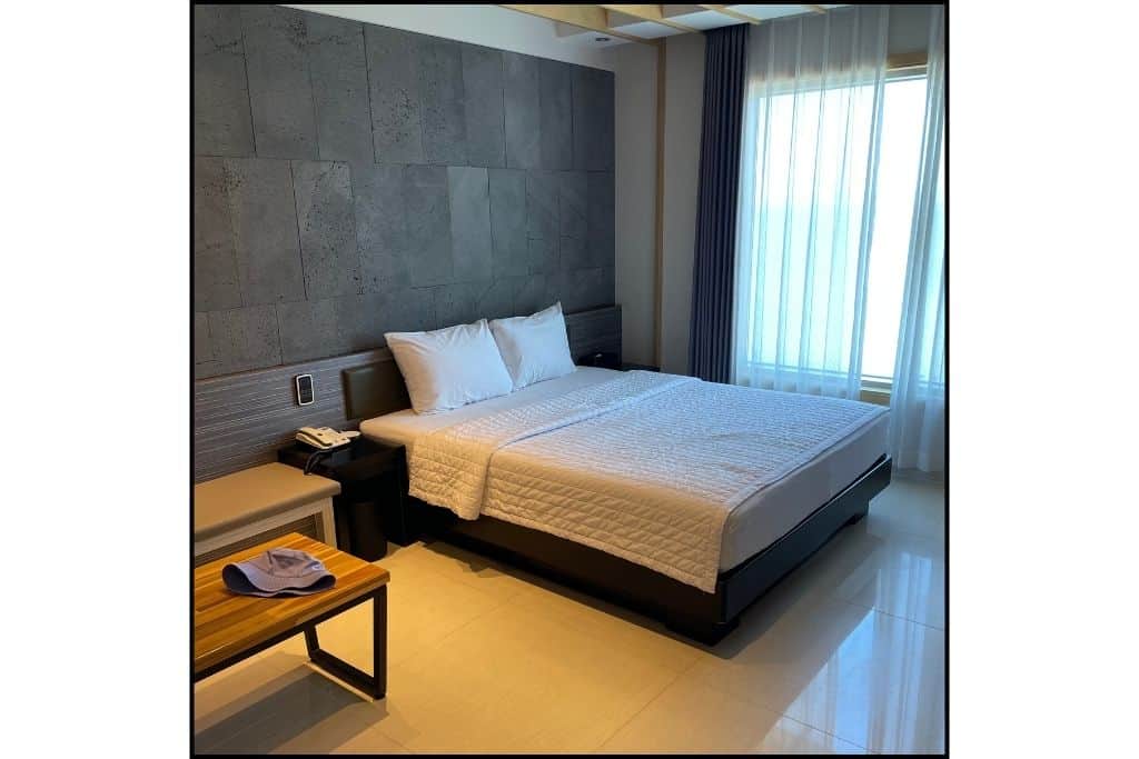 A photo of a a queen size bed in a hotel room in South Korea