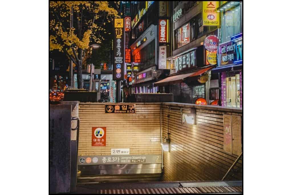 Jongno 3 subway entrance with illuminated building signs in the vibrant Jongno district of Seoul at night.