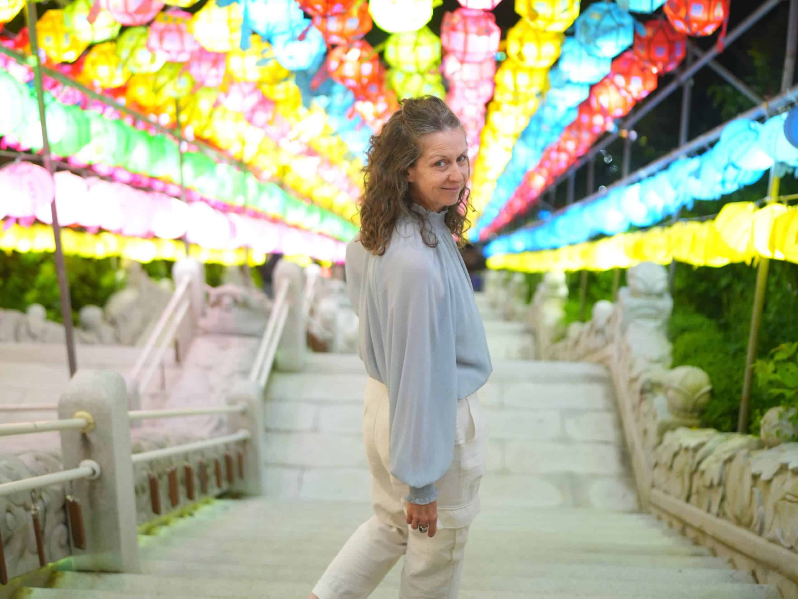 Walking down the stairs at Samgwangsa Temple during the Lotus Lantern Festival, surrounded by a vibrant canopy of glowing lanterns.