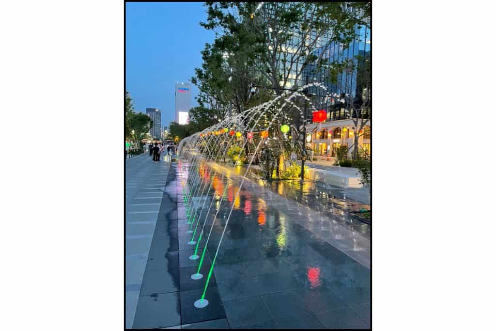 Colorful fountains lit up at night in Gwanghwamun Square, one of the lively things to do at night in Seoul.