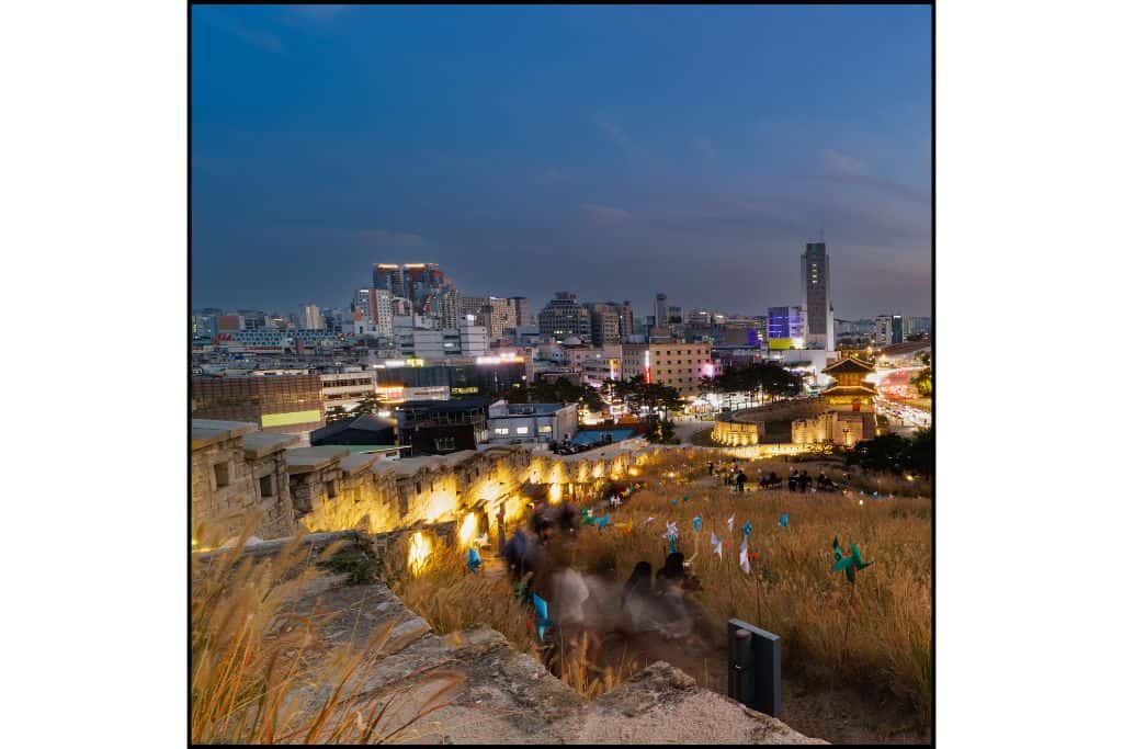 Nighttime view of Heunginjimun Park beautifully lit up with glowing lights—one of the peaceful things to do at night in Seoul.