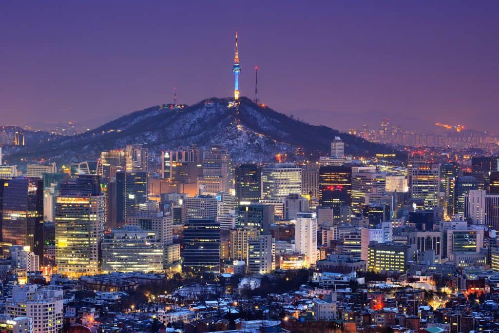 Panoramic view of Seoul at night with N Seoul Tower lit up and city lights glowing across the skyline