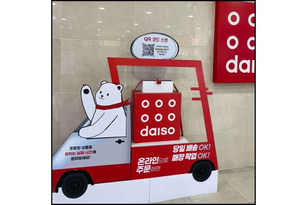 A Daiso sign , a popular dollar store in Souht Korea, with a polat bear driving a car.