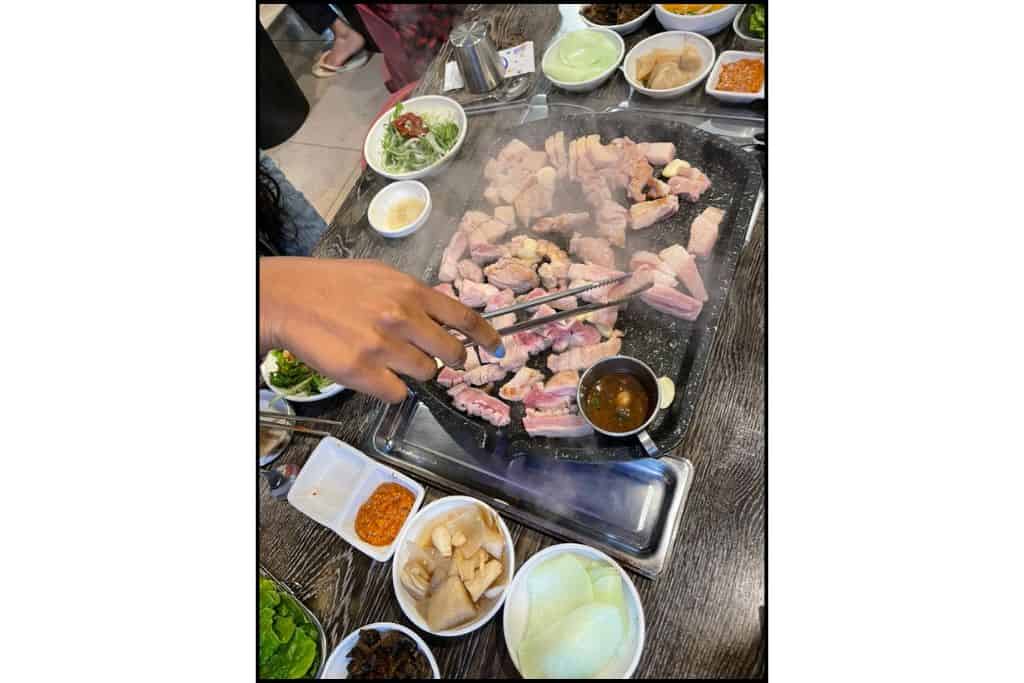 Grilled Jeju black pork served with Korean banchan side dishes at a traditional restaurant
