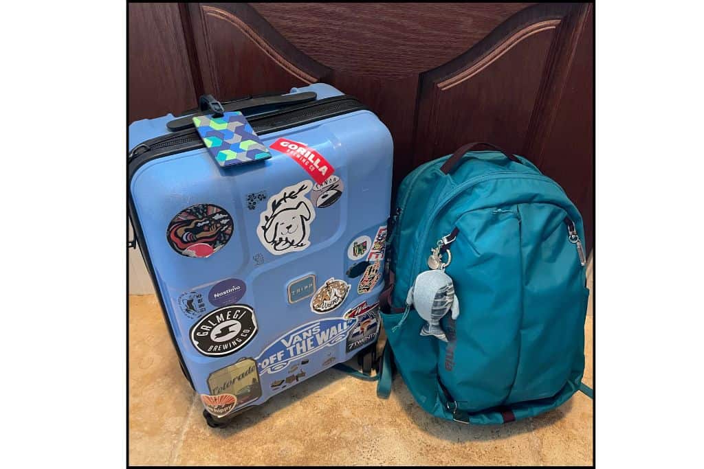 Packed carry-on full of stickers and backpack ready for a trip to South Korea.