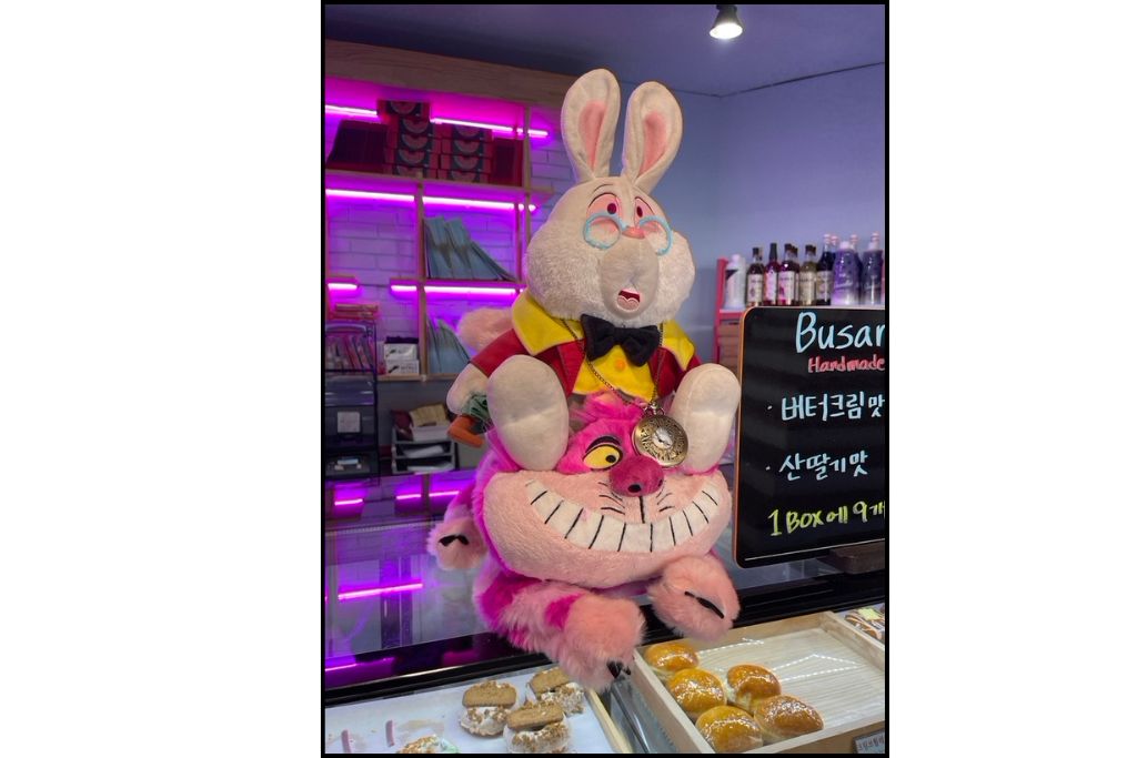 Alice in Wonderland plushies on the counter at a cute cafe near Haeundae Beach