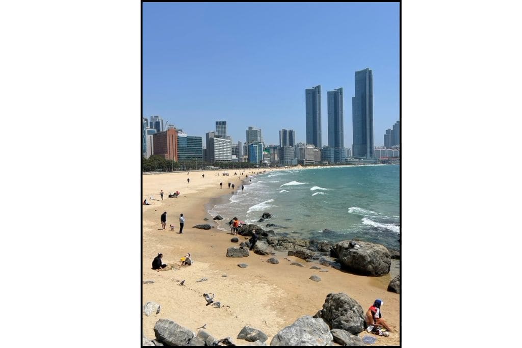 View of Haeundae Beach with skyscrapers and shoreline in Busan, South Korea.