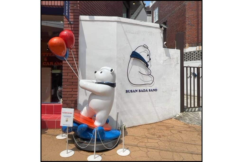 Polar bear statue with balloons outside Busan Bada Sand café near Haeundae Beach.