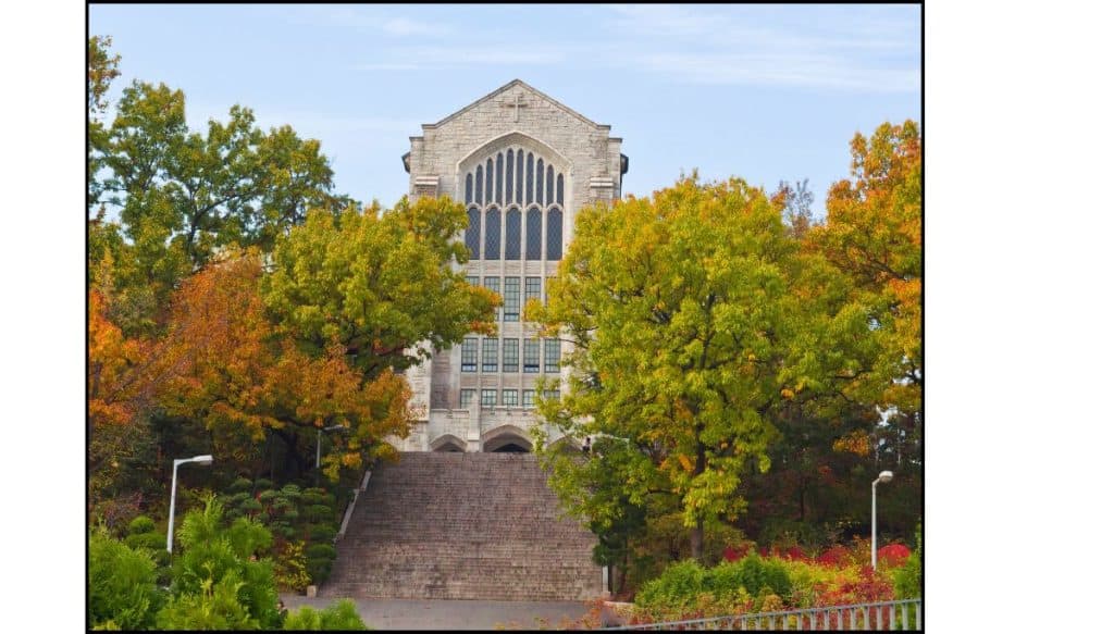 Grand stairway leading to Ewha Womans University building surrounded by fall foliage in Seoul, South Korea.
