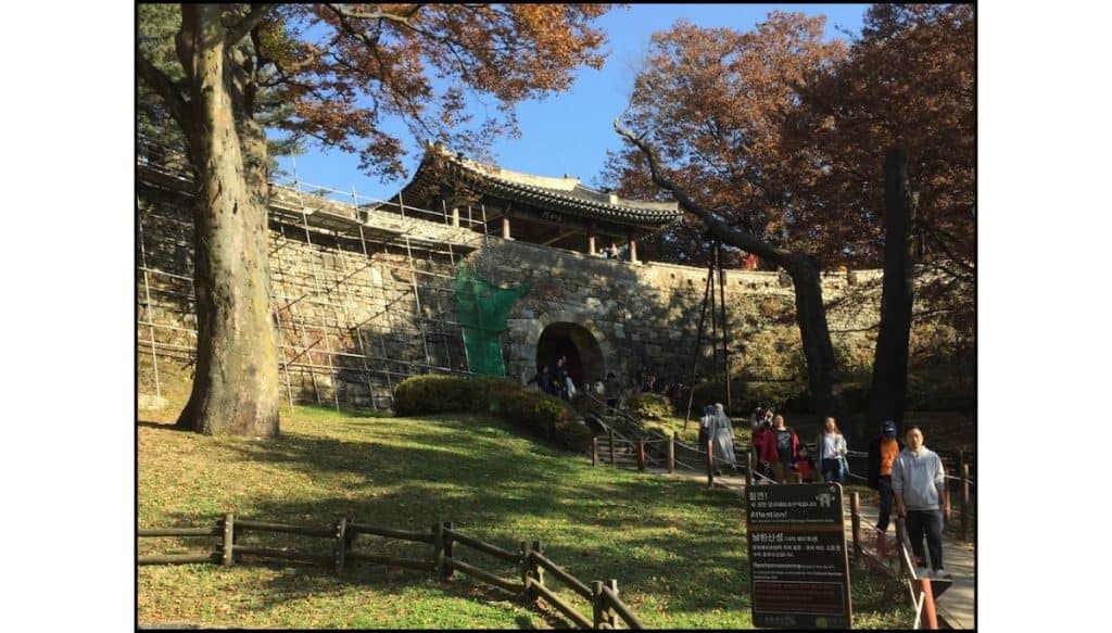 Namhansanseong Fortress gate surrounded by autumn foliage near Seoul, South Korea.