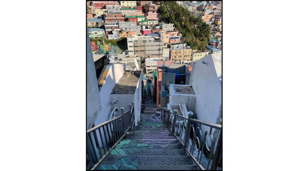 Steep stairs descending through Gamcheon Culture Village with colorful hillside houses below