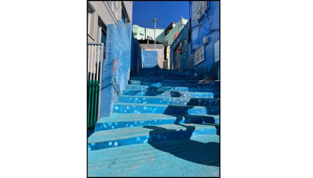 Blue stairway surrounded by painted buildings in Huinnyeoul Culture Village, Busan