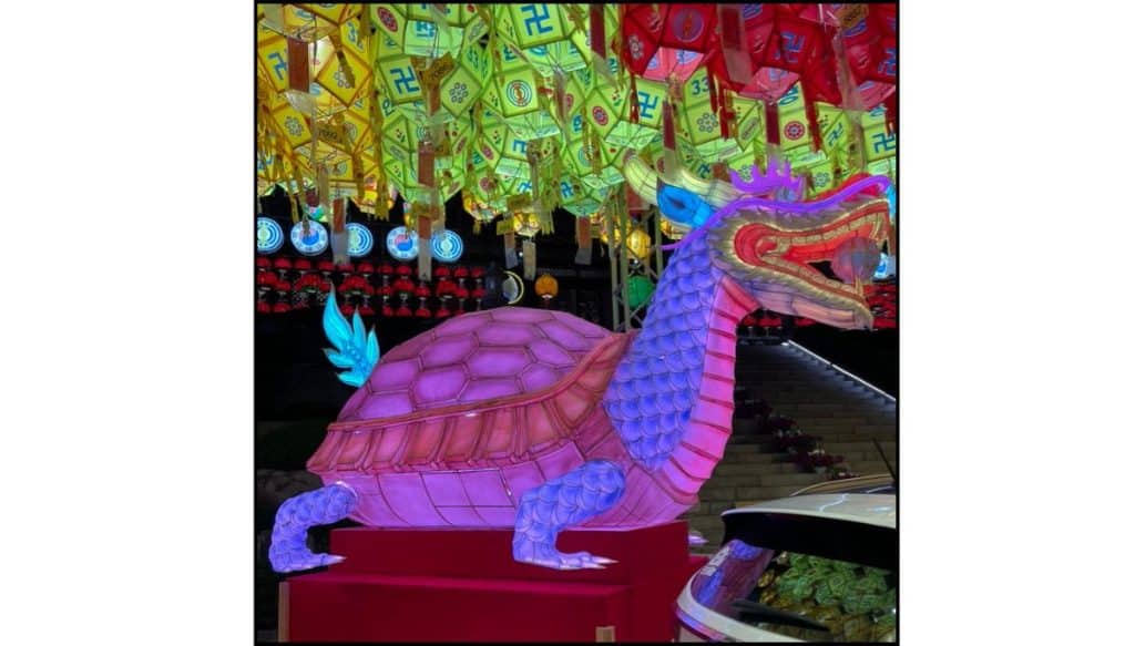 Illuminated turtle-dragon lantern beneath rows of colorful lotus lanterns at Samgwangsa Temple during the Buddha’s Birthday festival.