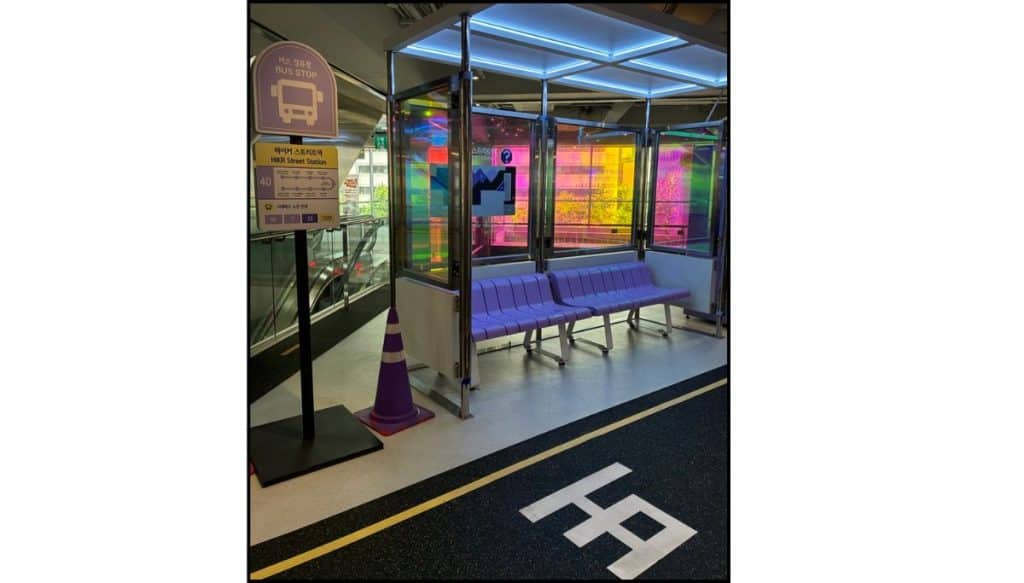 Small bus stop photo set with a bench, glass panels, and colorful lighting inside HiKR Ground.