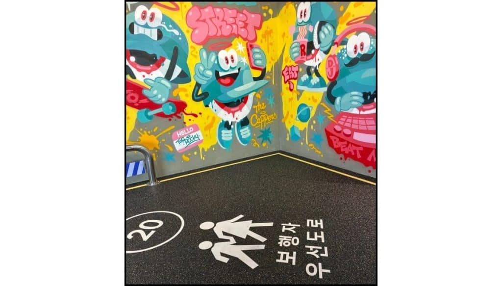Colorful street art wall with bright cartoon graphics and Korean lettering inside HiKR Ground.