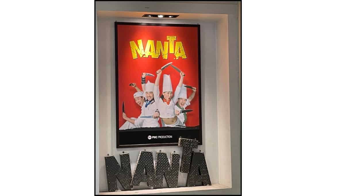 NANTA show poster in Seoul featuring performers dressed as chefs in front of a red background.