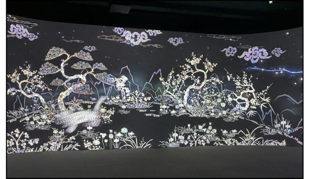 Immersive Digital Gallery at the National Museum of Korea featuring mother-of-pearl-style Korean art with flowering trees, mountains, clouds, and a bird on a panoramic screen.