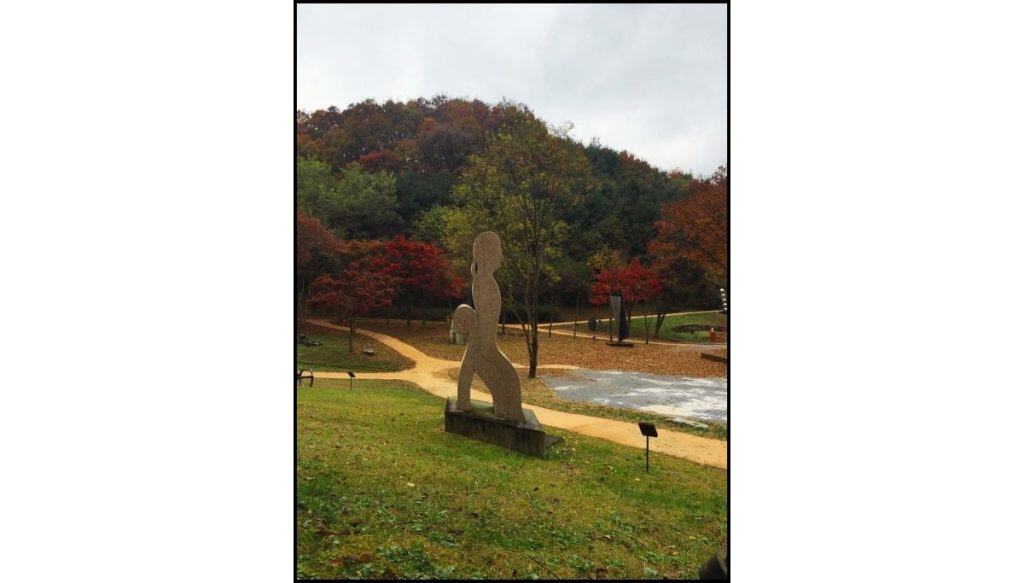 Autumn foliage and outdoor sculptures along a walking path at Gonjiam Ceramic Park in Gonjiam, South Korea.
